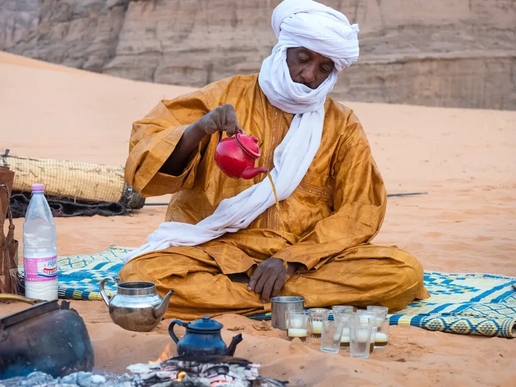 Close up of reza foam crown on freshly poured Moroccan mint tea in colorful painted glass