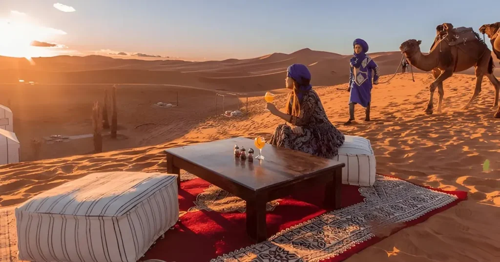 Moroccan mint tea served at sunset beside Sahara desert campfire in Erg Chebbi Merzouga