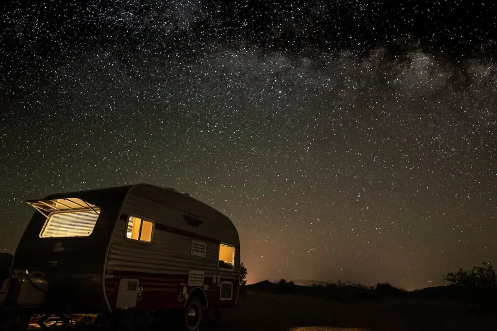 Motorhome wild camping in Morocco desert landscape under starry night sky