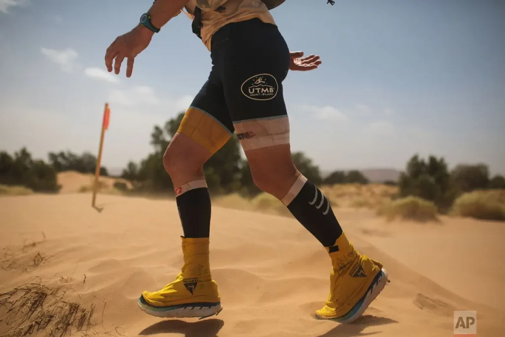 Trail running shoes with sand gaiters on desert sand for Marathon des Sables
