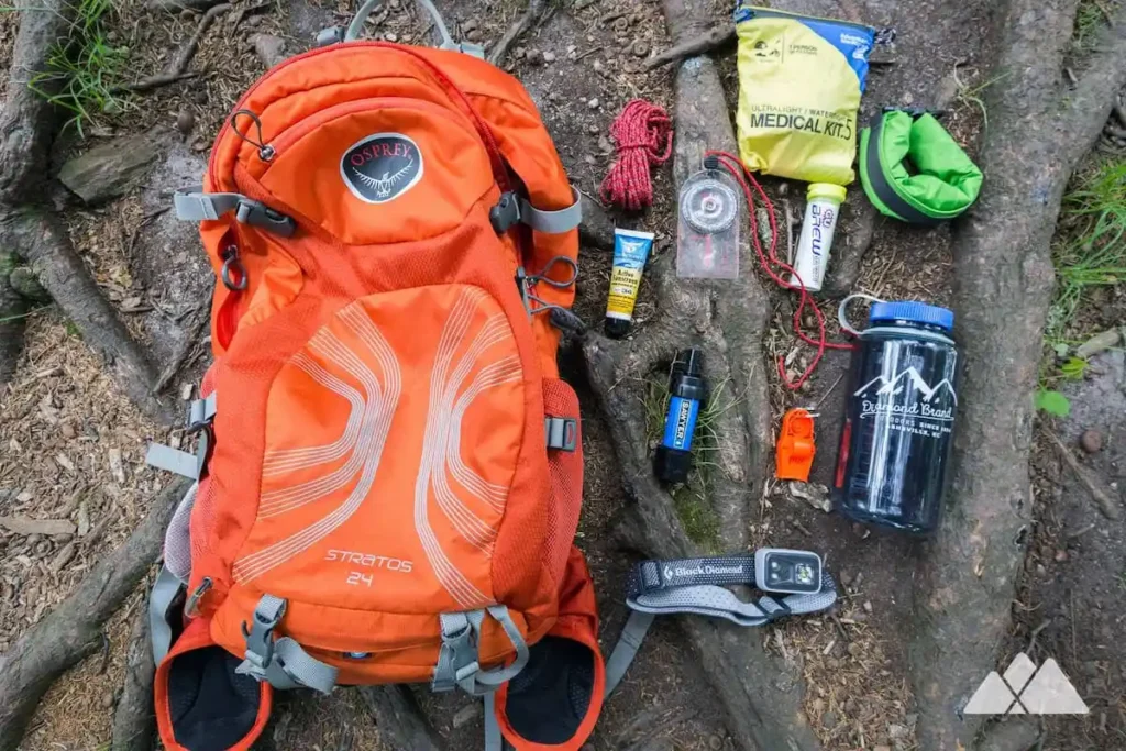 Trail running backpack and survival gear laid out for Marathon des Sables kit list