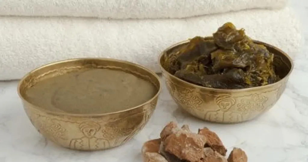 Moroccan hammam ritual savon beldi black soap and kessa glove on marble surface