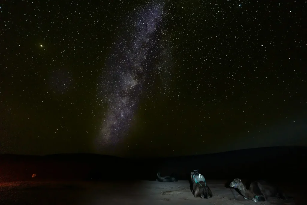 Milky Way and starry sky above sand dunes in Sahara Desert Morocco