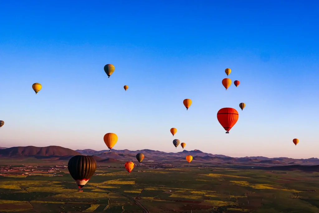 Colorful hot air balloon in Marrakech flying over the Atlas Mountains at sunrise