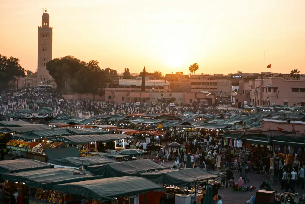 Jemaa el-Fnaa square at sunset with families and market stalls